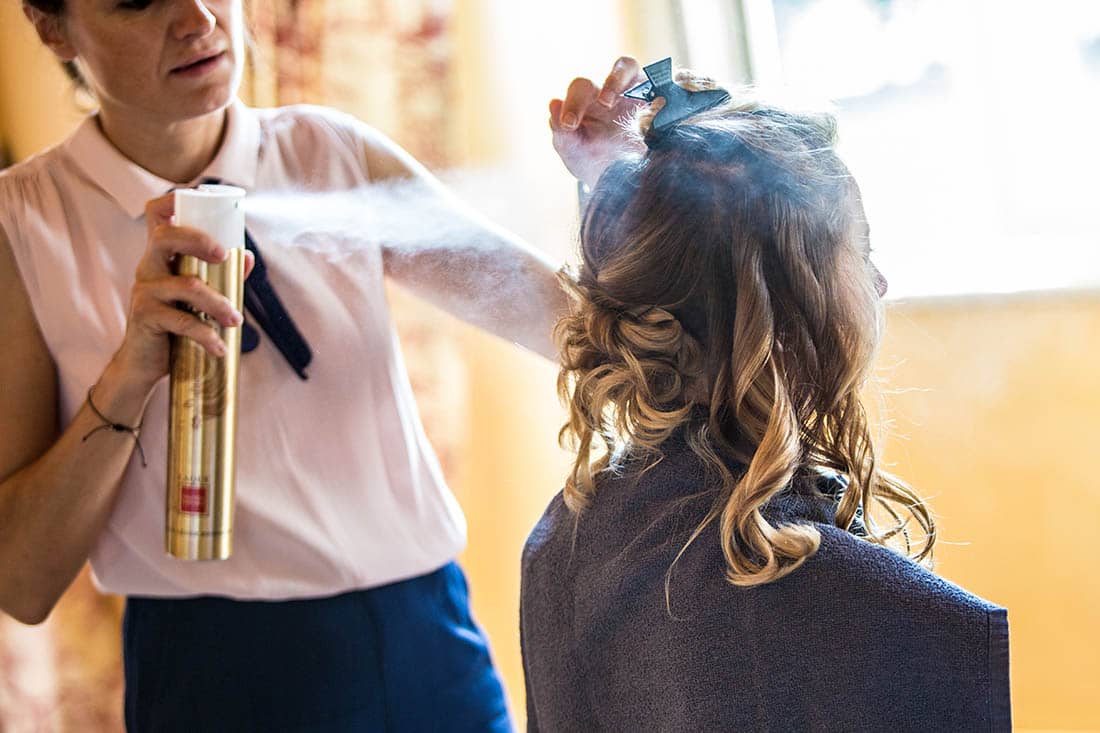 spray-cheveux La coiffeuse met de la laque
